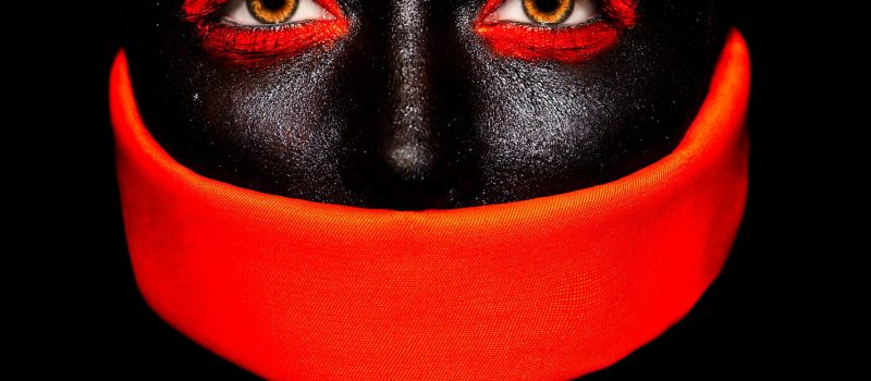 High fashion look.glamour fashion beautiful black American woman in black mask with orange bright makeup and orange material